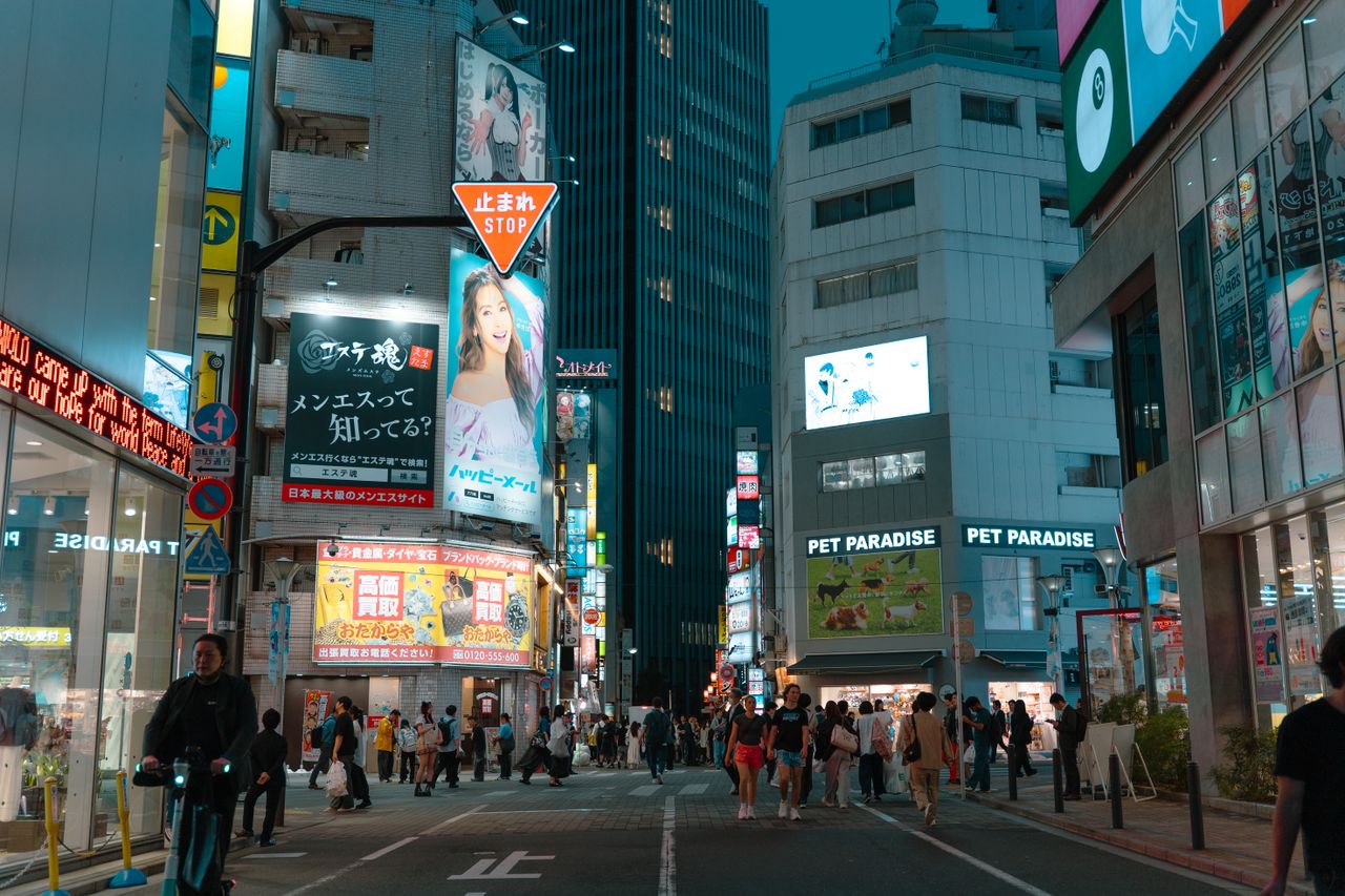 Captivating night view of a bustling street in Tokyo filled with lights and people.